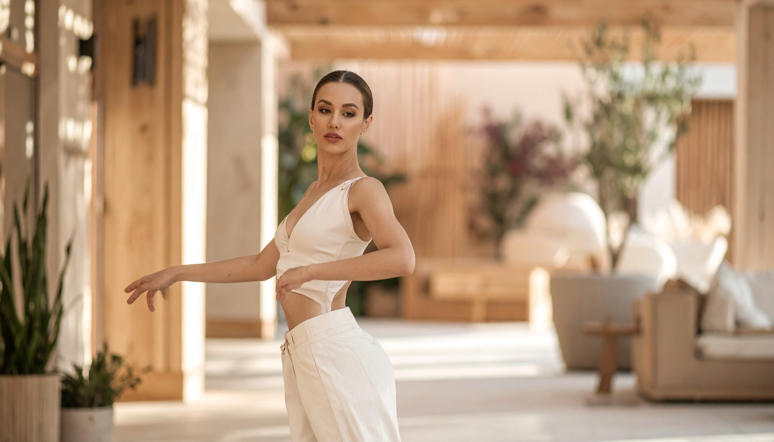 A woman in cream separates mid-turn across a sunlit terrace