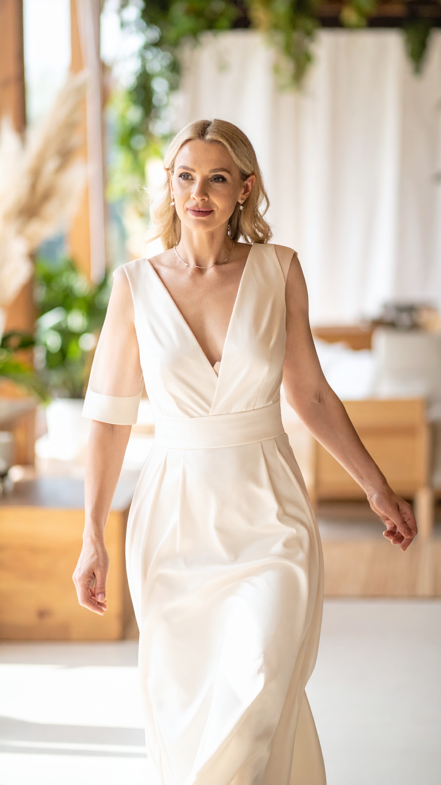 A woman in a soft gown in a warm interior, half-sleeve catching the light